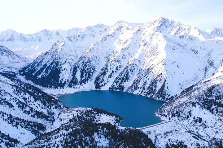 Veduta aerea del Lago Big Almaty circondato da montagne innevate.